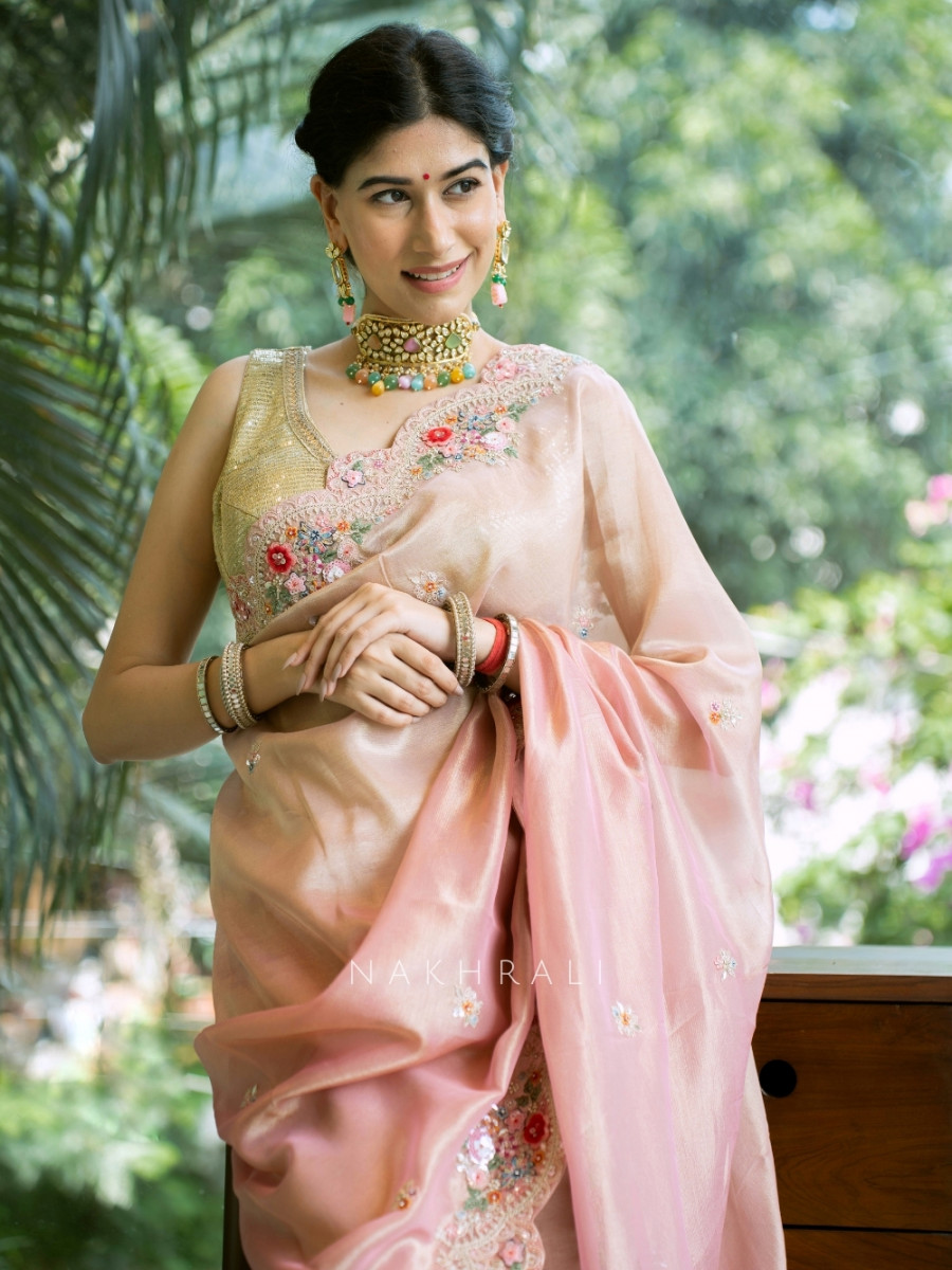 Stylish woman wearing pastel pink floral embroidered saree