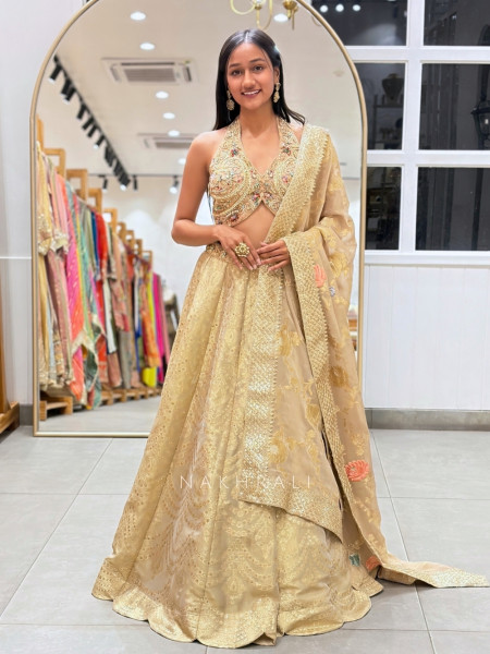 Kanakriti Beige Banarasi Brocade Silk Lehenga Set With Jewel Embellished Halter & Zari Work