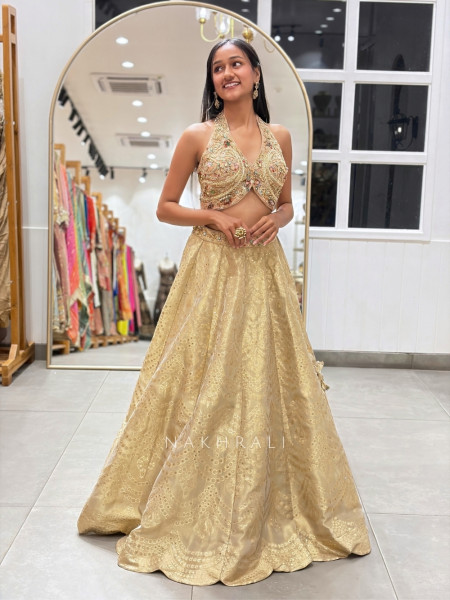 Kanakriti Beige Banarasi Brocade Silk Lehenga Set With Jewel Embellished Halter & Zari Work