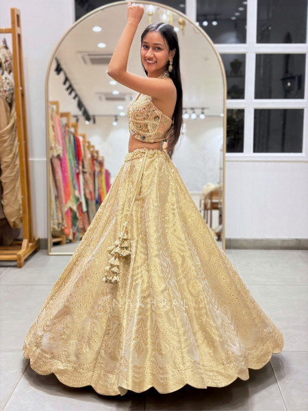 Kanakriti Beige Banarasi Brocade Silk Lehenga Set With Jewel Embellished Halter & Zari Work