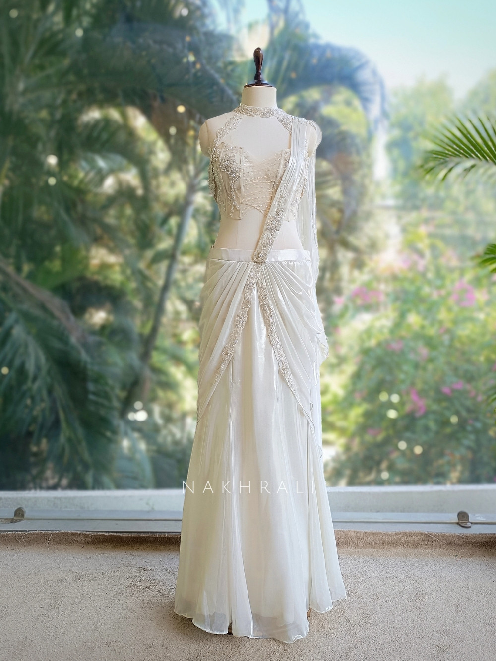 Structured Ivory Drape An ivory organza drape saree featuring delicate pearl and sequin ...