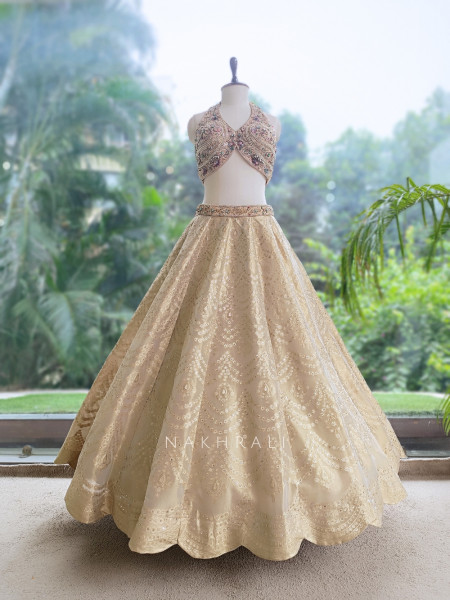 Kanakriti Beige Banarasi Brocade Silk Lehenga Set With Jewel Embellished Halter & Zari Work