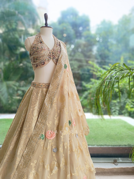 Kanakriti Beige Banarasi Brocade Silk Lehenga Set With Jewel Embellished Halter & Zari Work