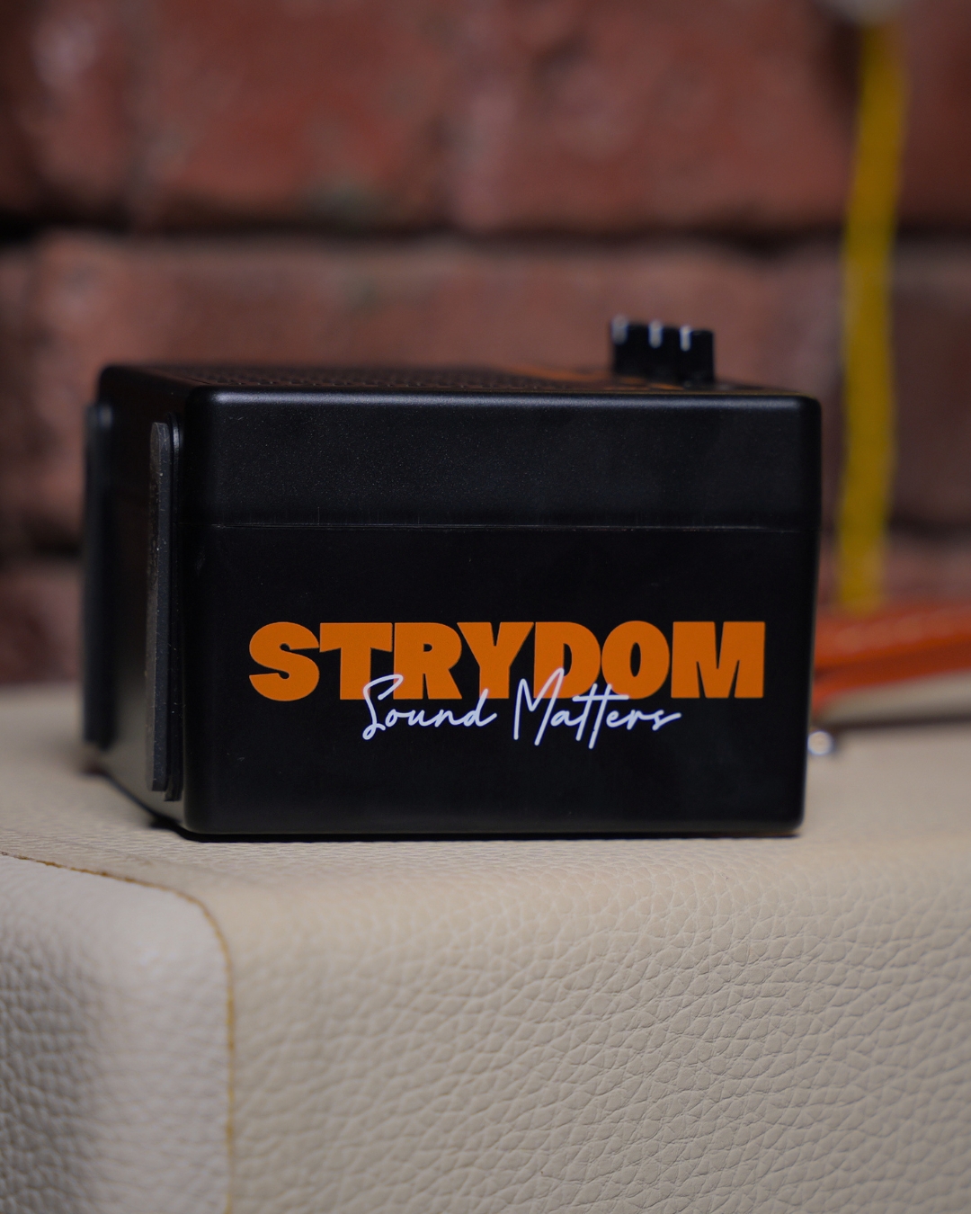 Strydom Mini Riot 8W Bluetooth Guitar Amplifier Coal - amp top with Strydom logo lifestyle shot