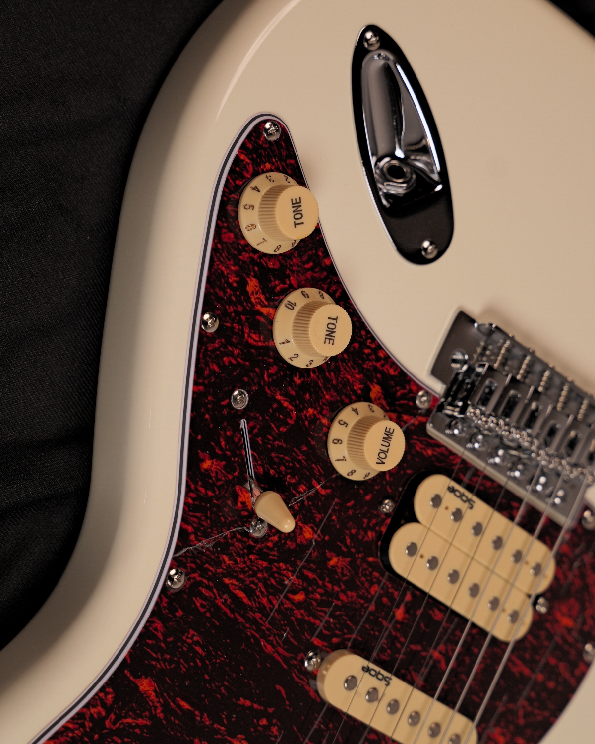 SQOE SEST250 Olympic White HSS Electric Guitar - tortoise pickguard and HSS pickups close-up