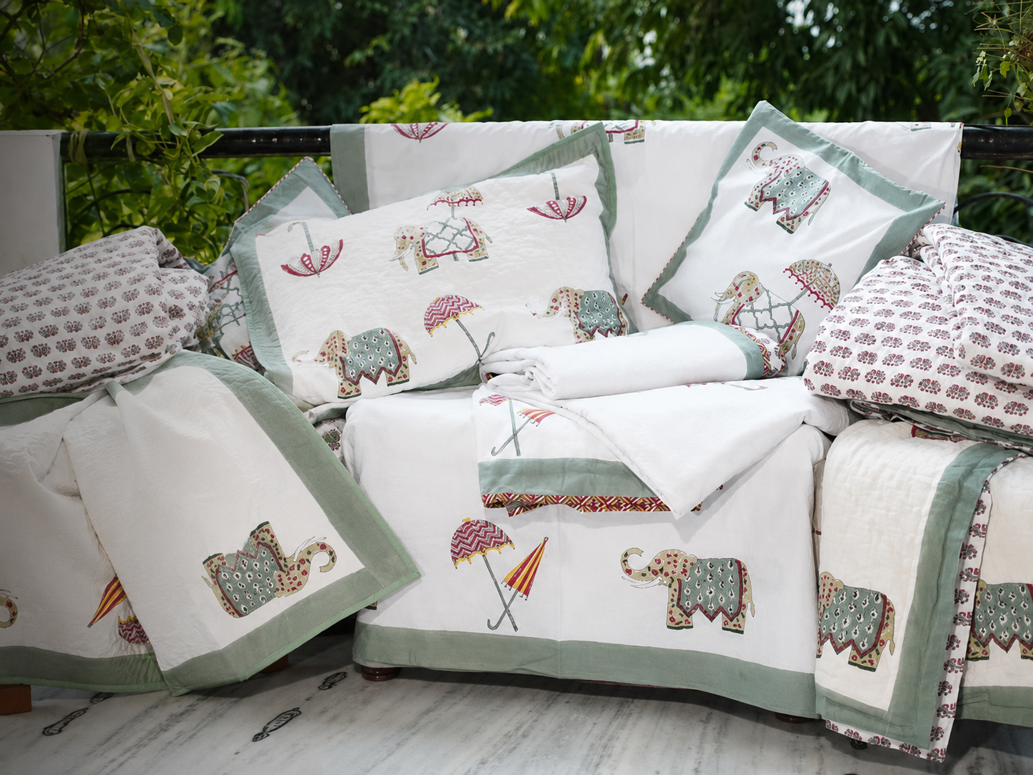 Coordinated block print bedding set with matching pillow shams, bedsheet and quilt in an elephant and umbrella motif