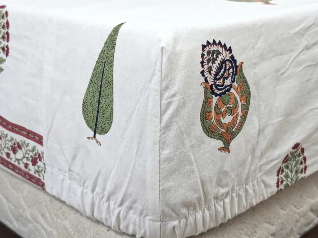 Close-up of a fitted block print bedsheet corner showing the elasticated pocket gathered around the mattress