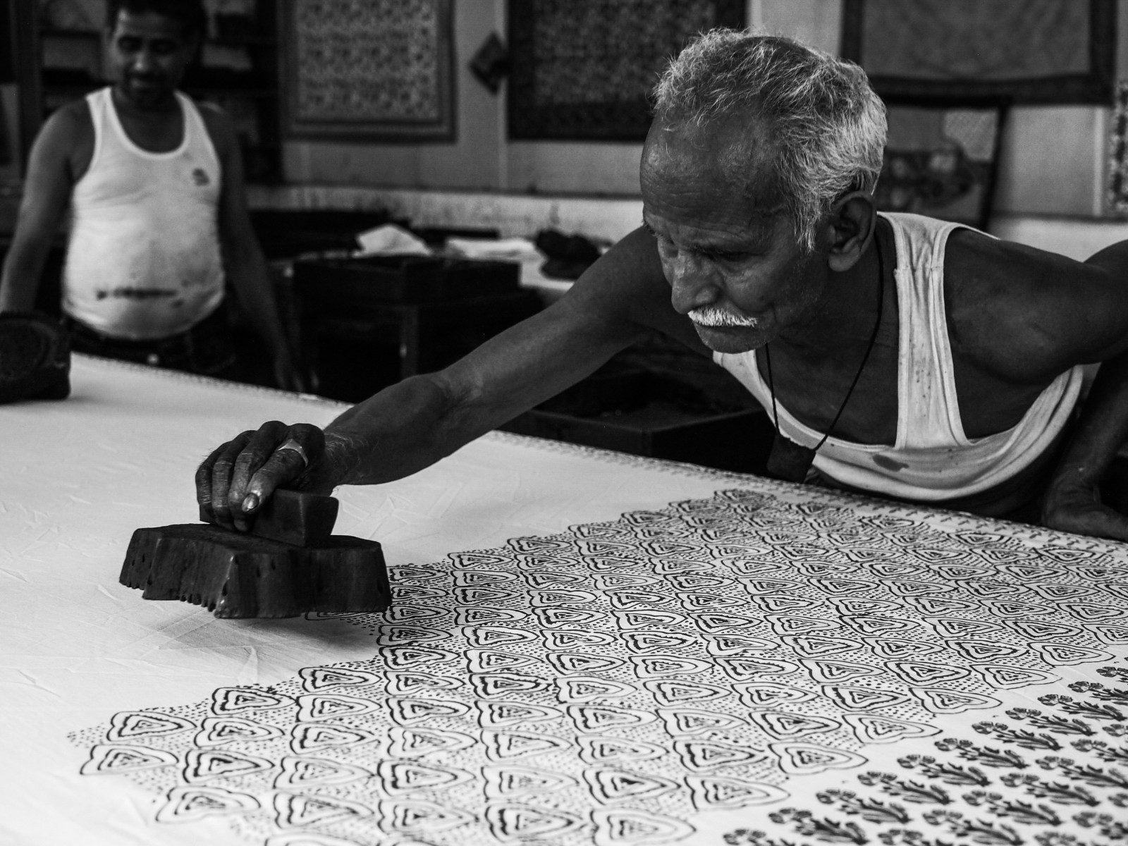 Jaipur artisan stamping hand block print pattern on fabric using carved wooden block