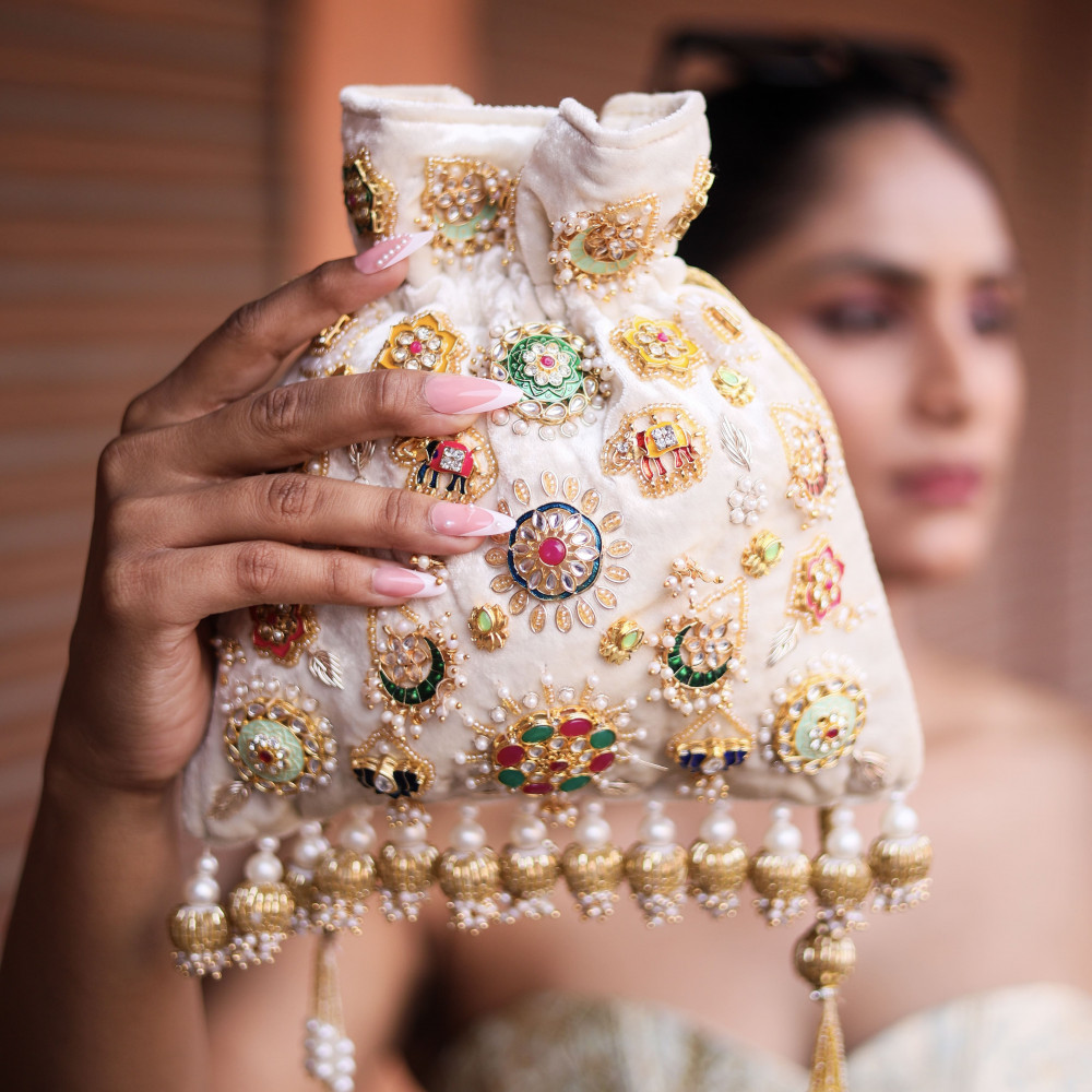 Image of Ivory Velvet Hand-Embroidered Potli Bag with Metal Charms &amp; Tassels