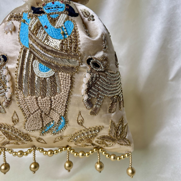 Light Beige Satin Silk Hand-Embroidered Krishna Cow Motif Potli Bag – Festive Wedding Gifting Bag