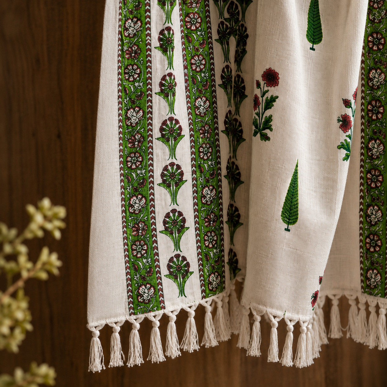 Close-up of green floral border and hand-knotted tassels on cotton handblock print throw