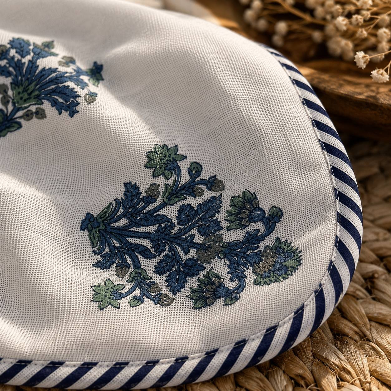 Close-up of blue floral bouquet print with navy striped piping border on cotton dohar