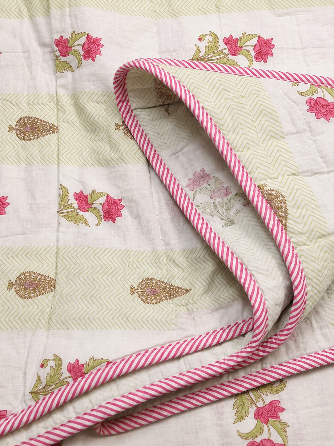 Close-up of cotton dohar with pink candy-striped piping and floral herringbone print