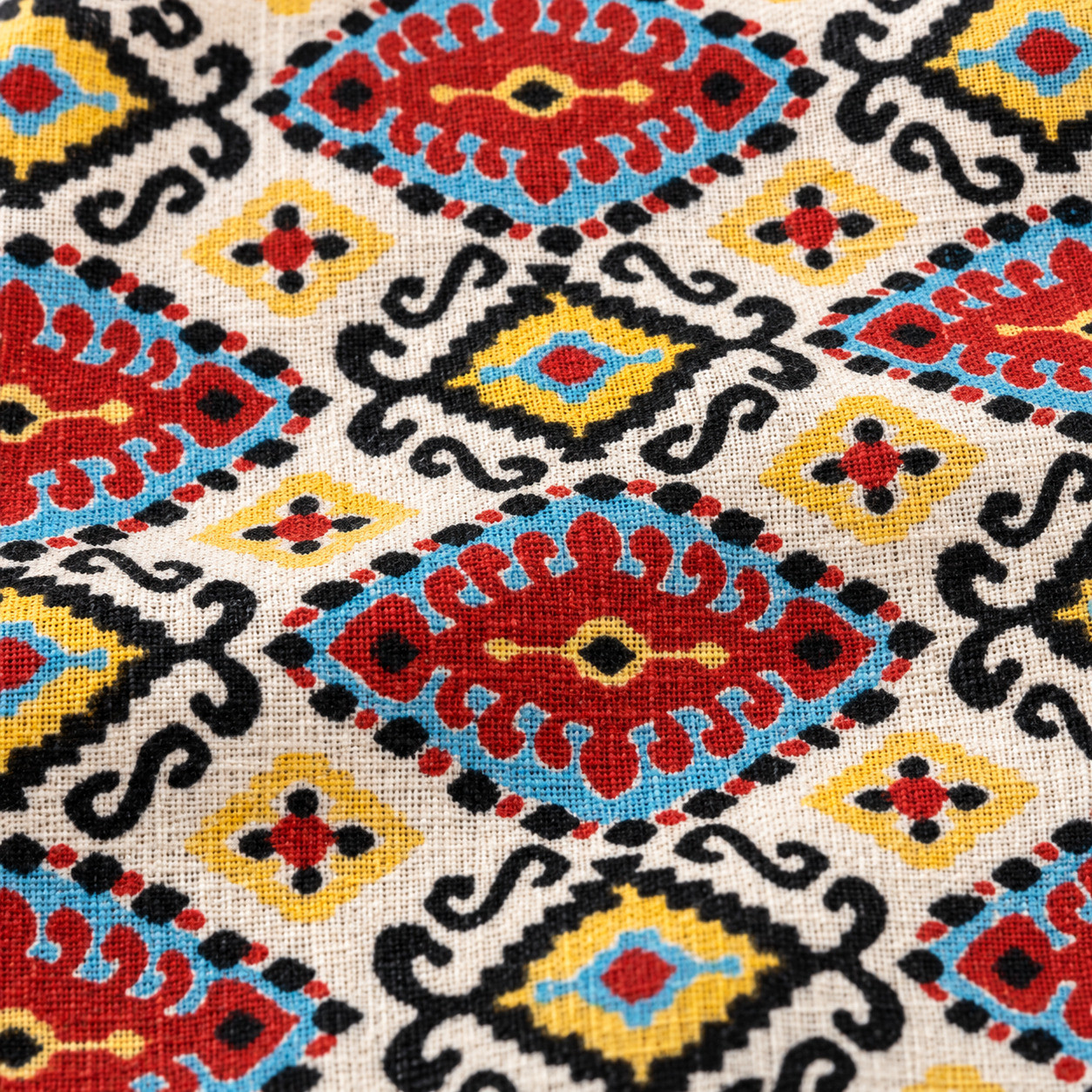 Close-up of hand block printed Aztec Kilim diamond pattern on cotton fabric texture