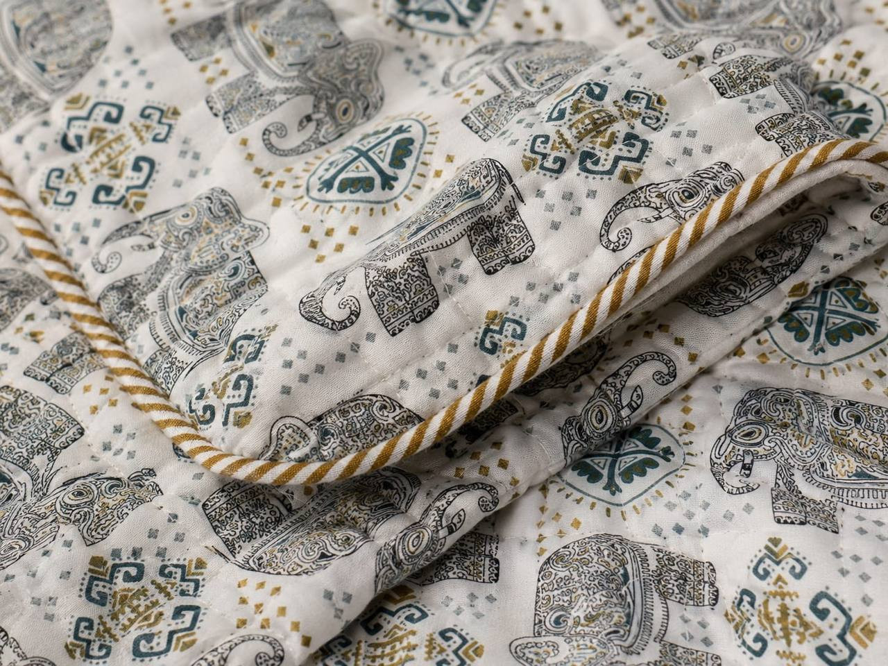 Close-up of hand block printed elephant motif dohar showing gold piping detail
