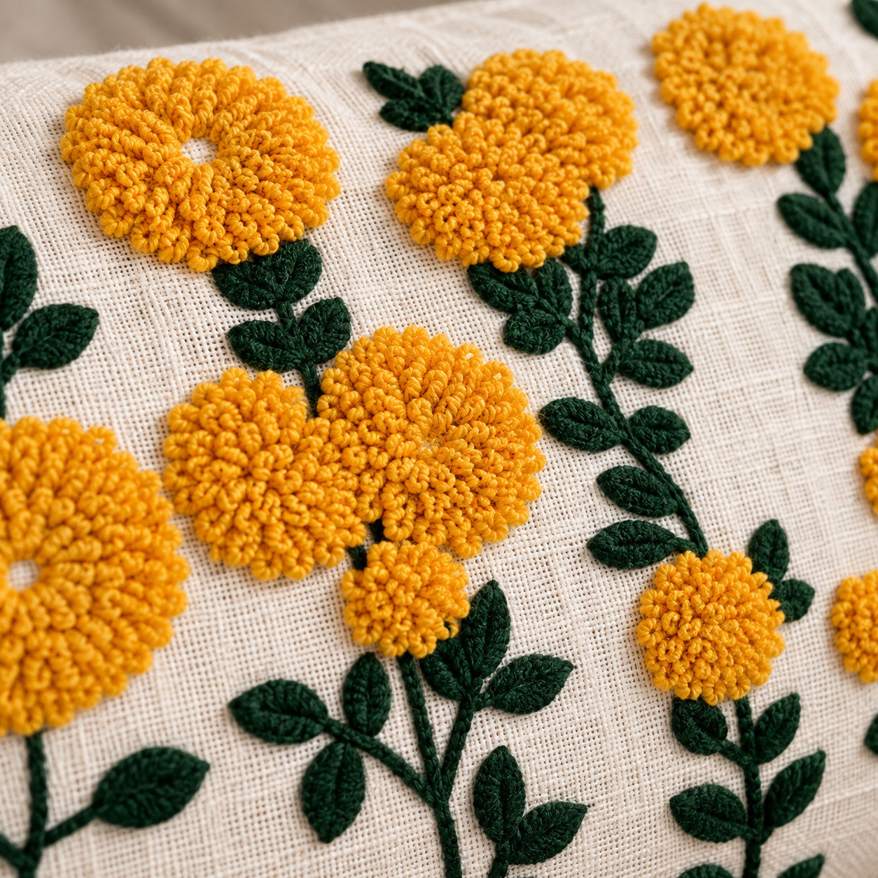 Close-up of hand embroidered mustard marigold flowers with dark green leaves