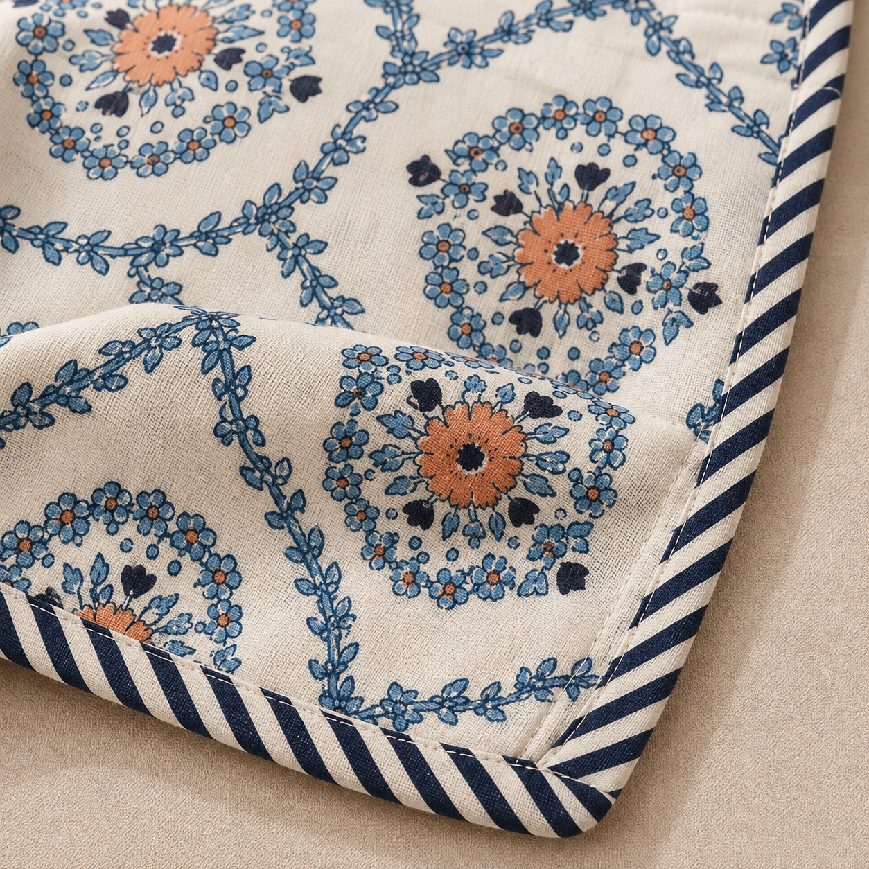 Close-up of indigo medallion cotton dohar corner showing floral wreath print and navy striped binding