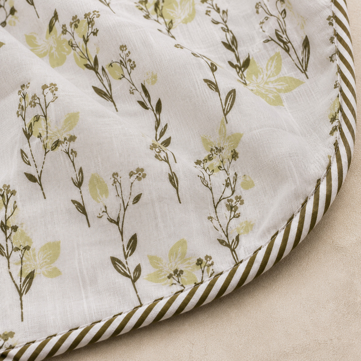 Close-up of sage wildflower hand block printed cotton dohar corner showing floral stem print and striped piping edge