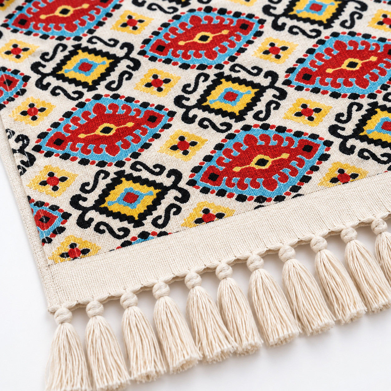 Close-up of tassel fringe detail on red teal Kilim diamond medallion cotton throw