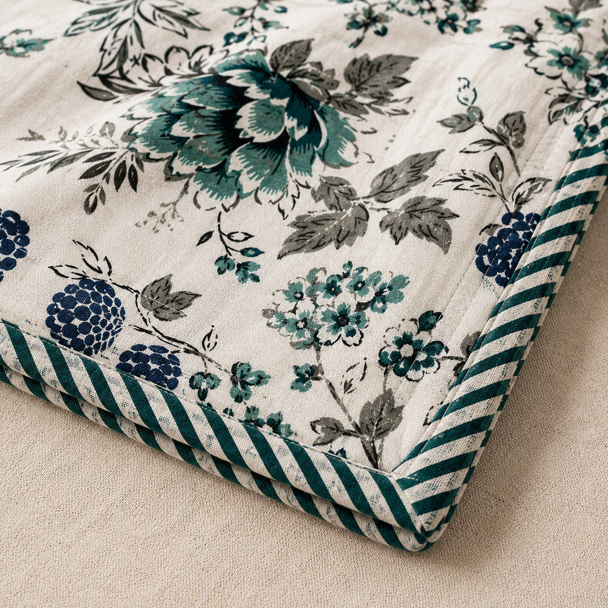 Close-up of teal botanical cotton dohar corner showing floral bouquet print and striped teal piping