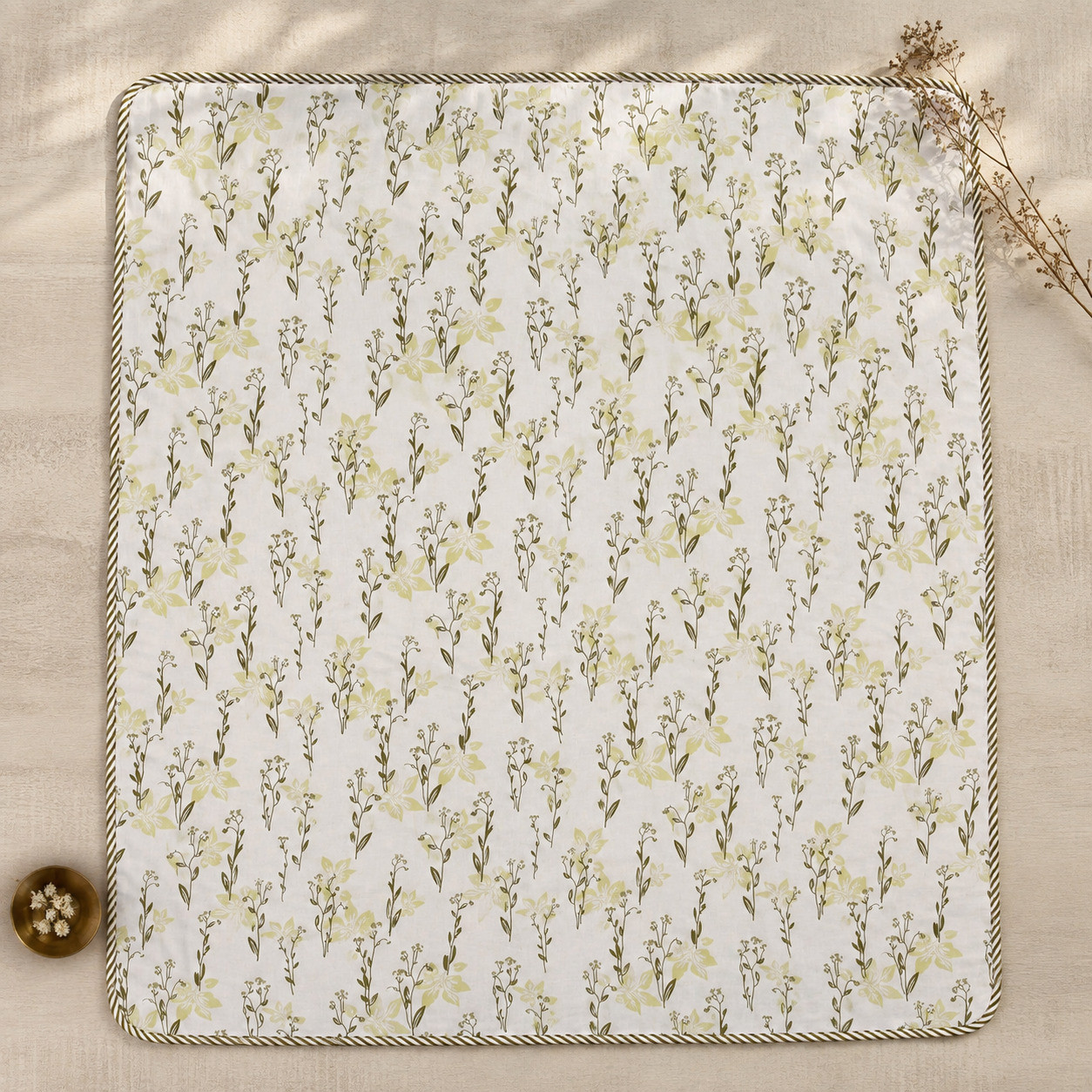 Flat lay top view of sage wildflower hand block printed cotton dohar showing full botanical print with cord edge