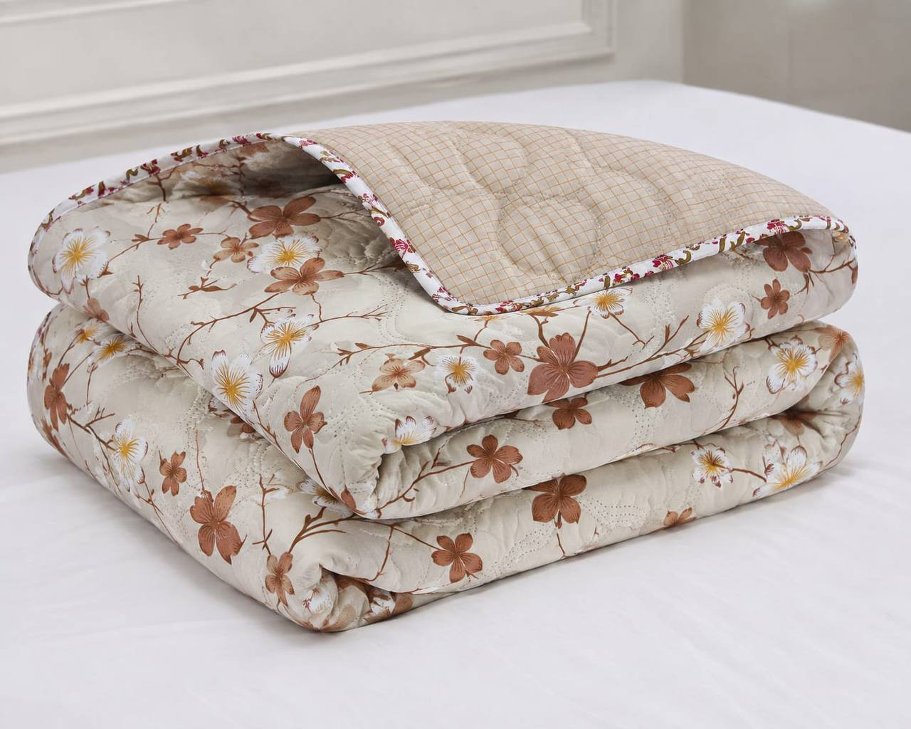 Folded cotton quilted comforter in ivory blossom print with reversible beige checked pattern and pink floral piping