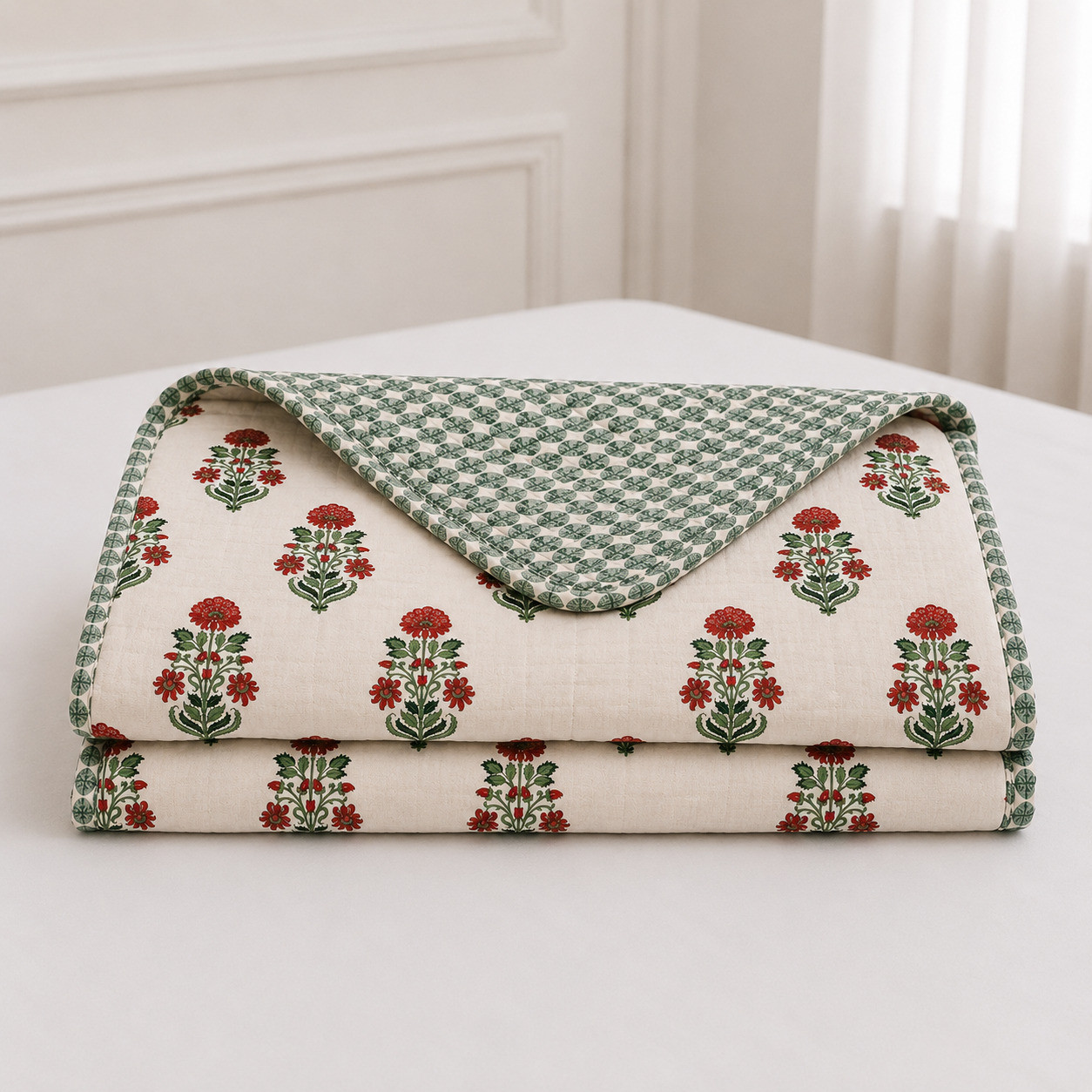 Hand block printed reversible cotton dohar red floral and green print folded on bed