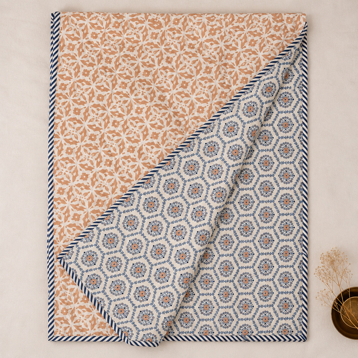 Indigo medallion hand block printed cotton dohar folded diagonally showing reversible terracotta floral print with striped border