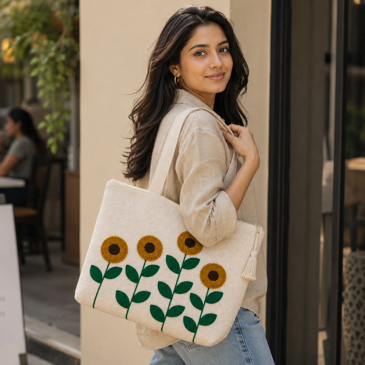 Woman wearing embroidered sunflower field tote bag outdoors on street