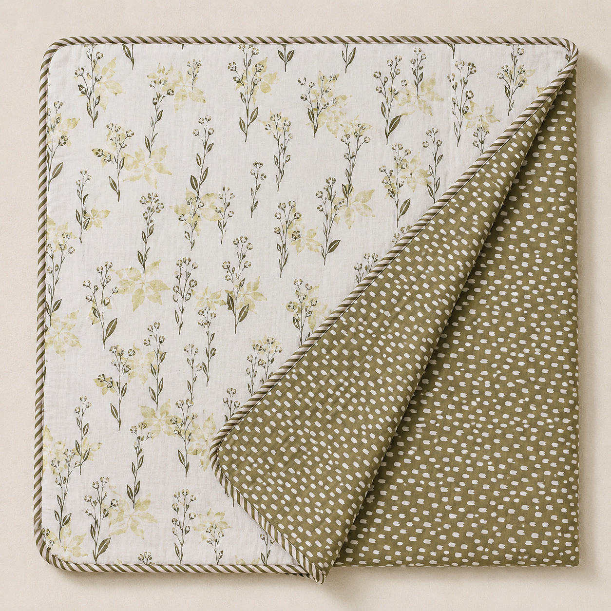 Sage wildflower hand block printed cotton dohar folded diagonally showing reversible olive polka dot print with striped cord border