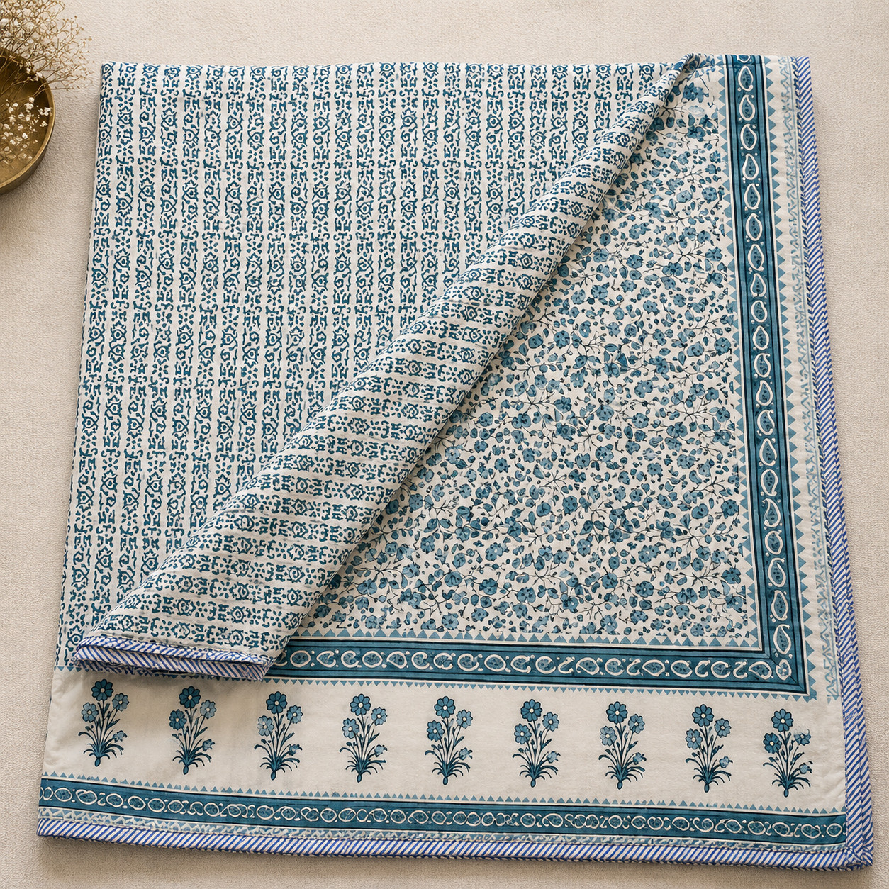 Teal floral vine hand block printed cotton dohar folded to show reversible geometric booti print and paisley border